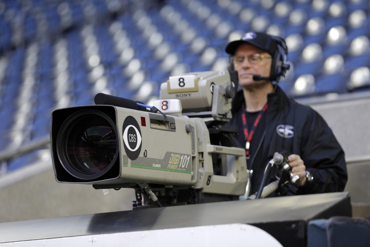 A CBS cameraman prepares before an NFL game earlier this season. CBS and the NFL have reached a deal to extend their Thursday Night Football agreement to 2015.