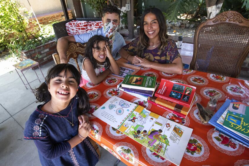 EL SERENO, CA - JULY 16, 2020: Left top right-Luna Tringale, 6, her sister Anaya Tringale, 5, father Rolando Tringale, 40, and mother Kamren Curiel, 41, are photographed in outdoor classroom, located in backyard of their home in El Sereno. Luna is a 2nd grader and Anaya is a kindergartner at Aldama Elementary School in Highland Park. When school resumes next month, all classes will be taught online because of the coronavirus outbreak. (Mel Melcon / Los Angeles Times)