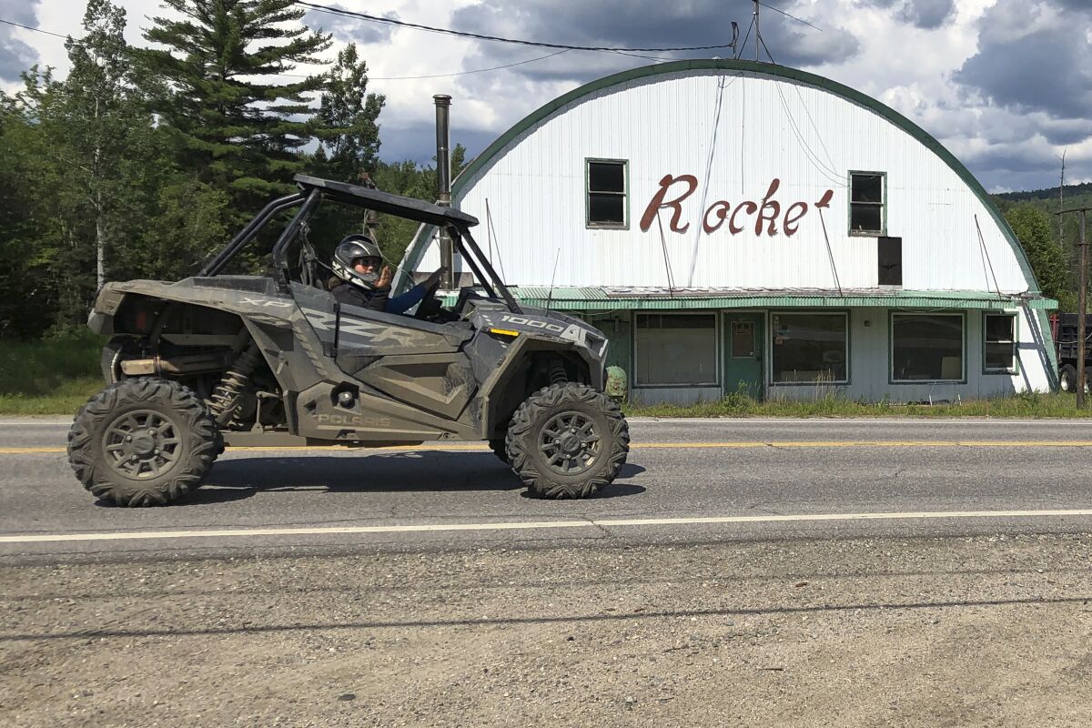 A utility terrain vehicle, or UTV, travels on a road, in Gorham, N.H., Friday, July 23, 2021. Rural communities across the country are wrestling with the economic perks and environmental drawbacks of opening up their roads to ATVs. Interest in ATVs has only intensified as more people got outdoors during the pandemic. (AP Photo/Lisa Rathke)