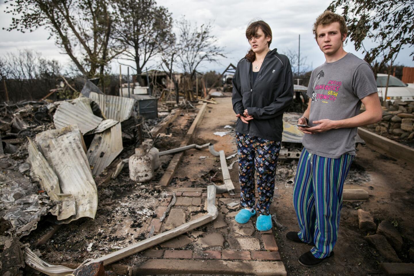 Andrew Eblen and his fiancee, Britany Carpenter, examine the ruins of their home, which was destroyed in the North fire. The couple recently renovated the home, Eblen's childhood residence, and was going to move in in a few months.