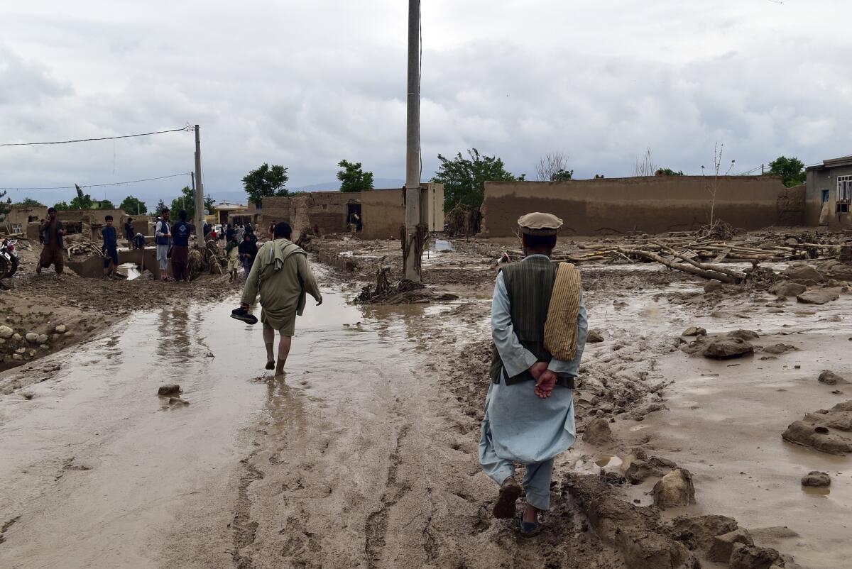 People walk along a flooded path in northern Afghanistan.