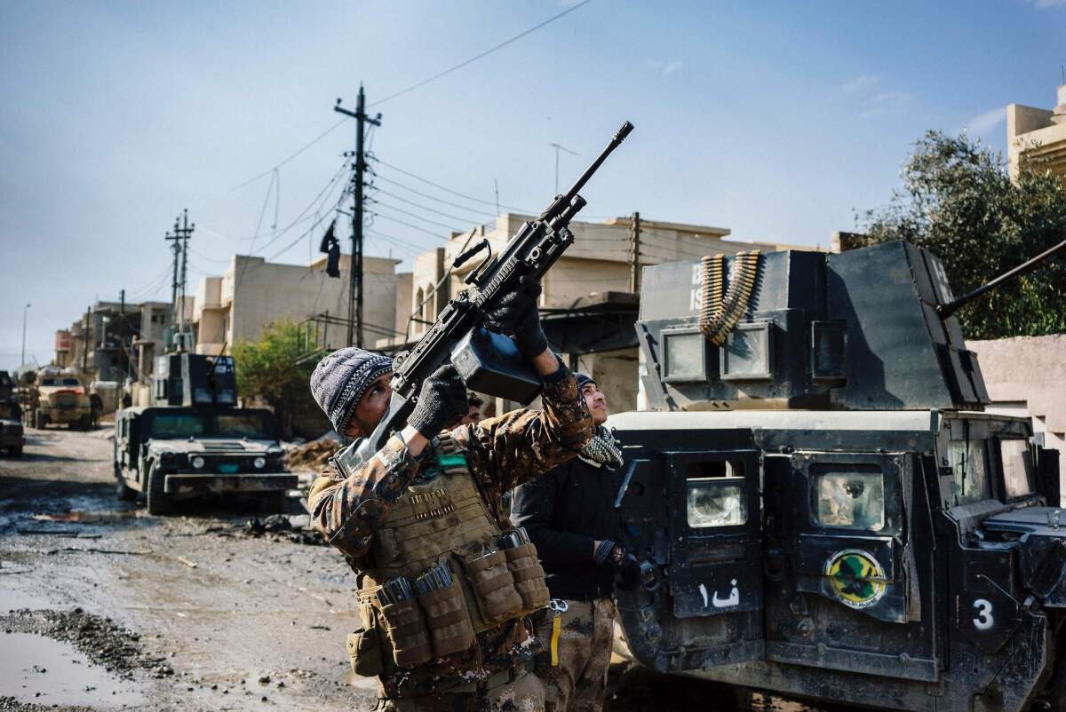 An Iraqi Counter Terrorism Service member shoots at a drone flown by Islamic State militants in Mosul's Rifaq neighborhood on Jan. 8, 2017.