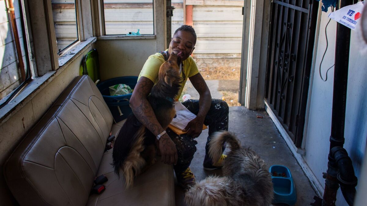 Tamara Meeks spends time with her dogs where she lives on the back porch of a friend's friend's house. She has been on the Section 8 waiting list for 13 years and finally just received notice she will be getting a federal housing subsidy.