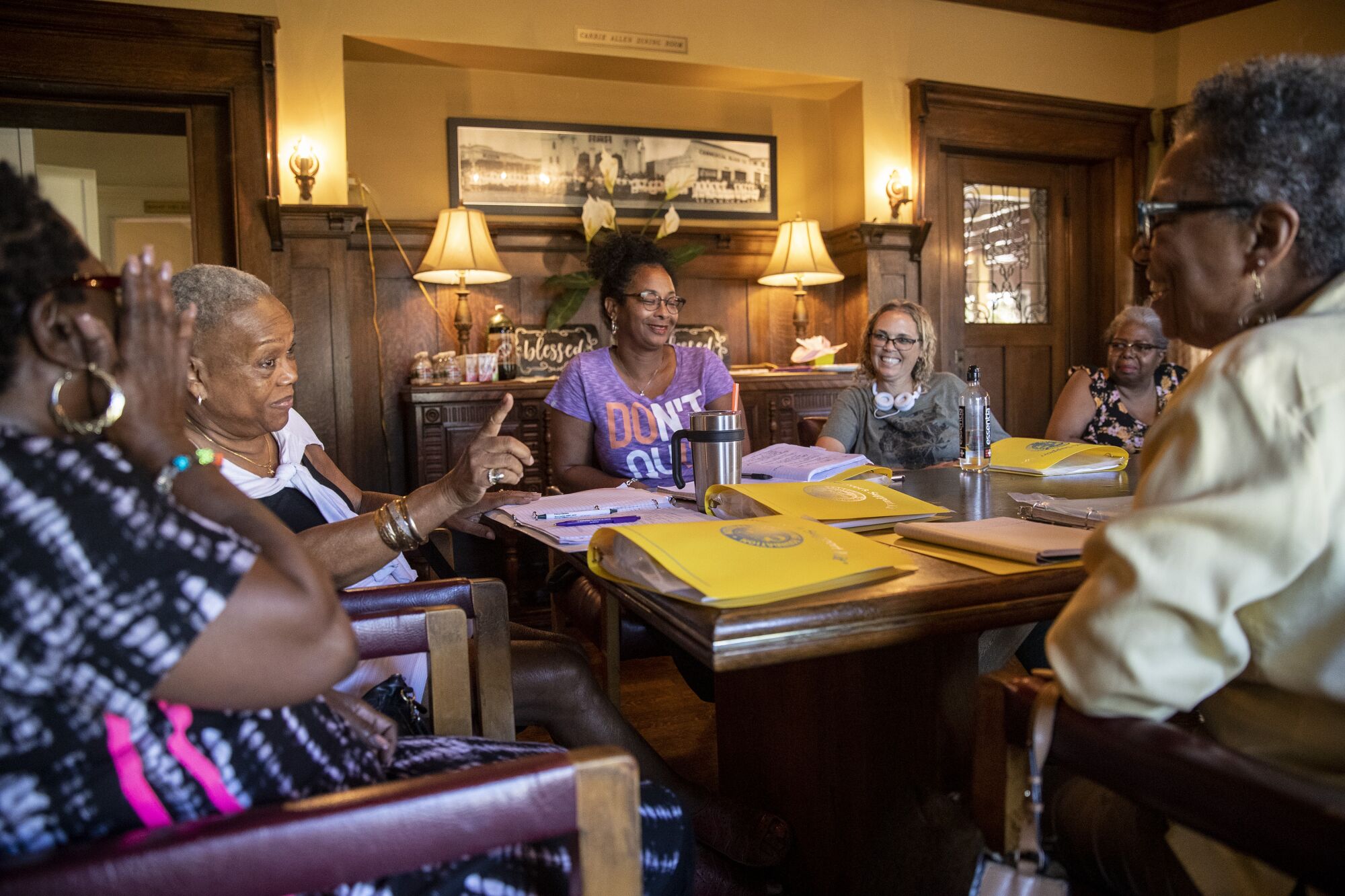 Women at a support group for family caregivers sit and talk around a table.