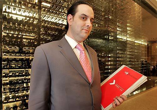 Mark Thomas, wine director of the Mix restaurant in the Mandalay Bay Resort and Casino, holds his restaurant's 38-page wine list. The wine case behind him is 45 feet wide.