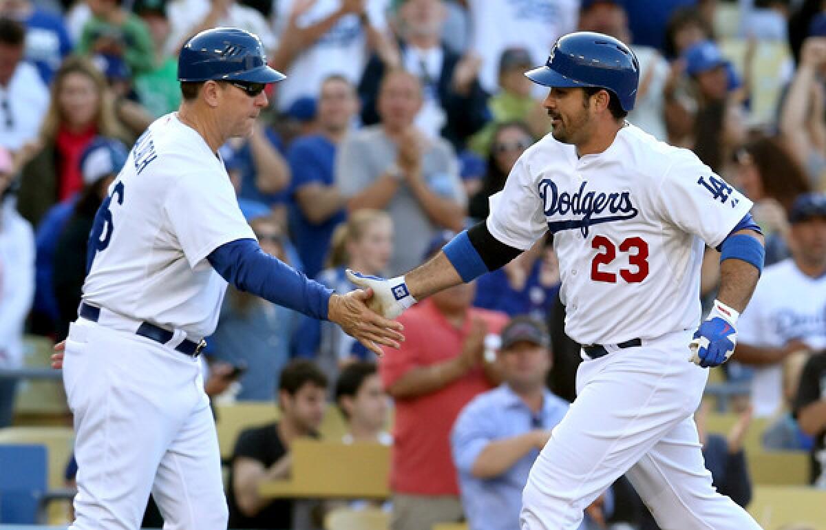 Dodgers first baseman Adrian Gonzalez (23) is congratulated by third base coach Tim Wallach after hitting a solo home run in the third inning Saturday evening.