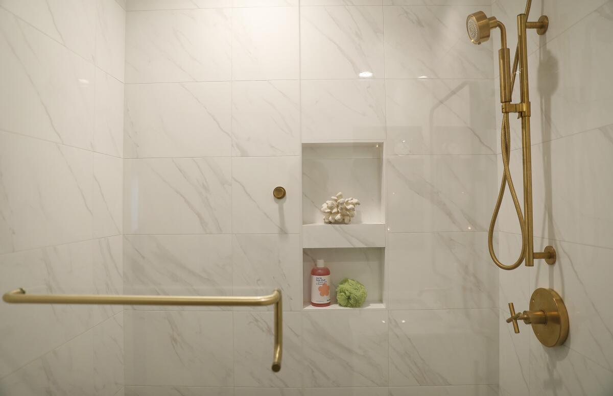 The bathtub was replaced with a shower with a frameless glass wall. The shower door handle doubles as a towel bar.