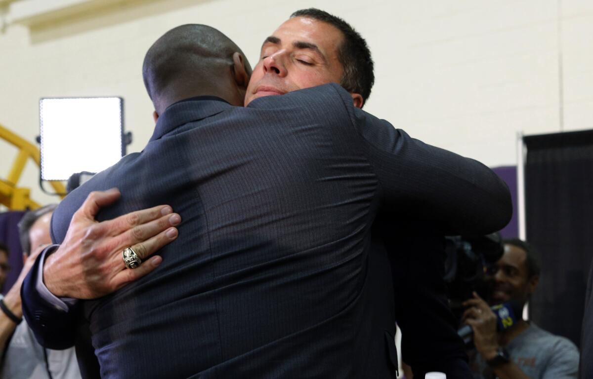 Kobe Bryant, left, hugs Rob Pelinka, at a news conference in El Segundo March 10, 2017.