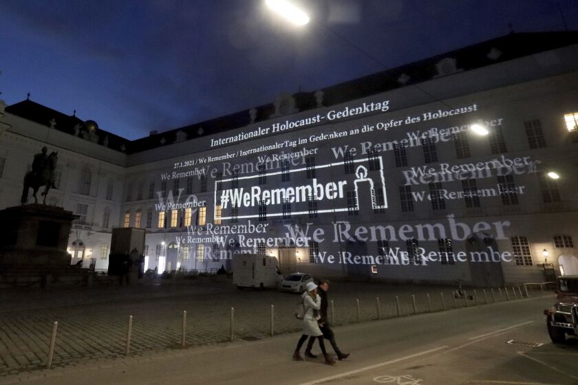 The words '#WeRemember' are displayed at the facade of the Austrian Parliament at the Hofburg palace in support of the campaign for the International Holocaust Remembrance Day in Vienna, Austria, Wednesday, Jan. 27, 2021. The anniversary of the liberation of the Nazi death camp Auschwitz is on Jan. 27, marking the International Holocaust Remembrance Day. (AP Photo/Ronald Zak)