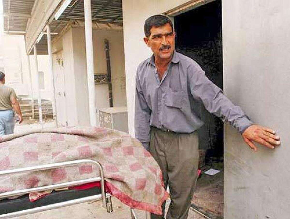 Abu Imad wheels a body into the freezer of the morgue at Baghdad's Yarmouk Hospital.