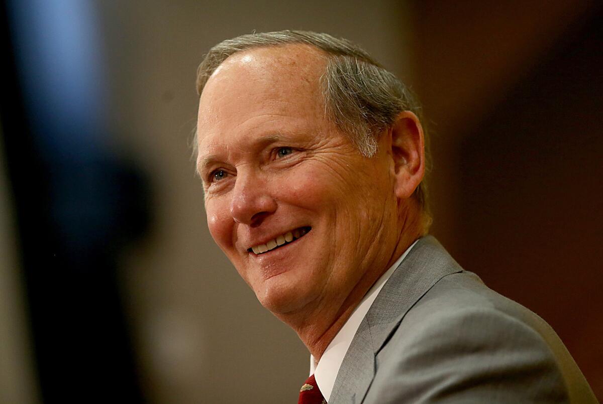 USC Athletic Director Pat Haden smiles as he speaks during an introductory press conference for Coach Steve Sarkisian on Dec. 3, 2013.