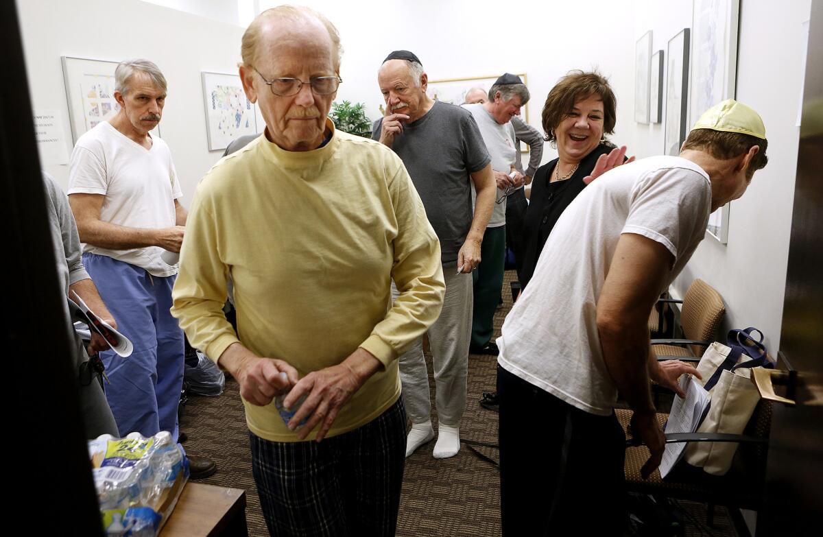 Denise Souder, second from right, assistant professor at the Keck School of Medicine of USC in Boyle Heights, greets actors gathered to play the role of David Solomon, a 70-year-old Orthodox Jew who is dying and receiving hospice care at his home.