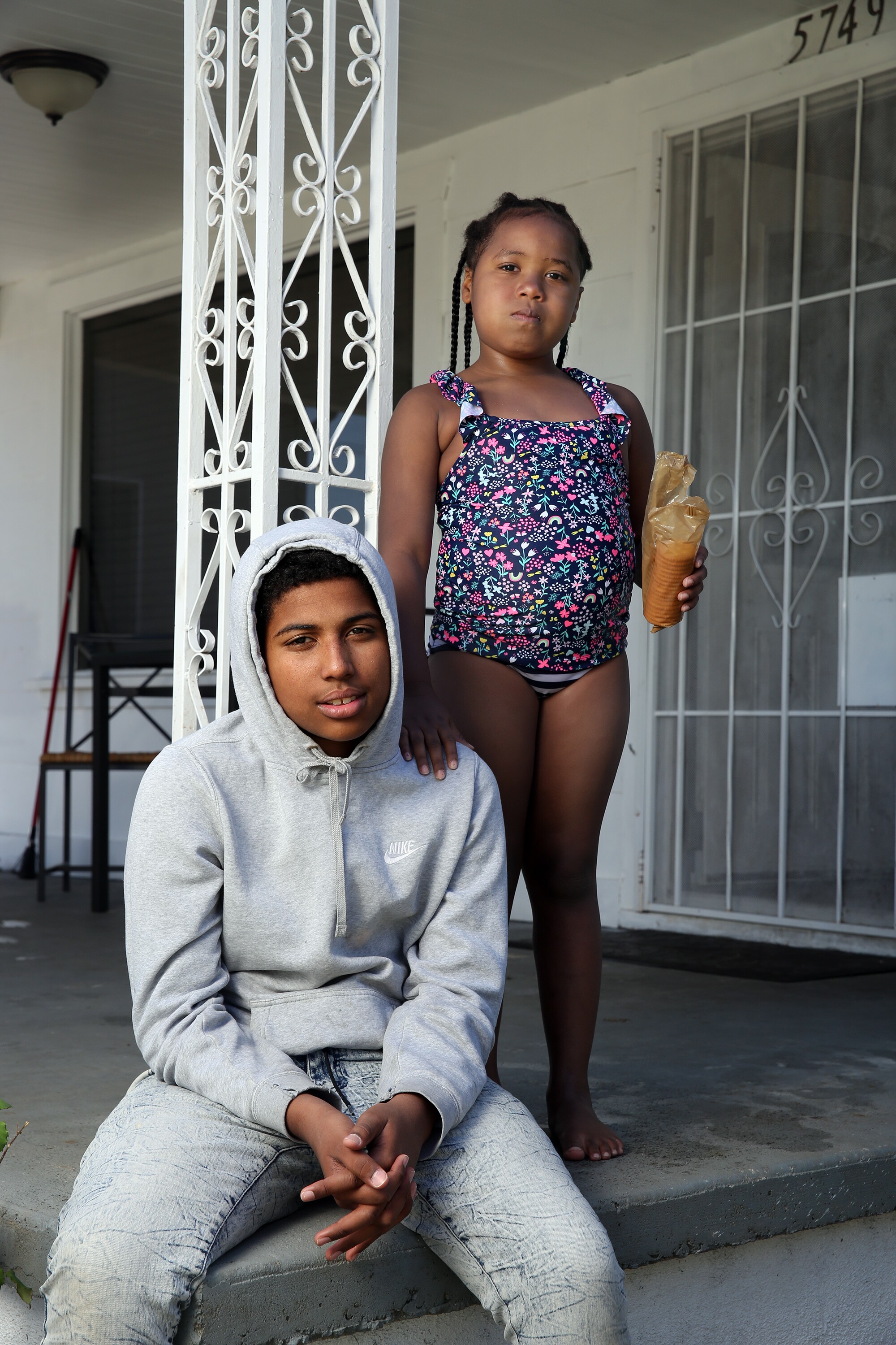 Manuel Ferguson, 16, sits on his front porch with sister Elese Bolden, 6, in South L.A.