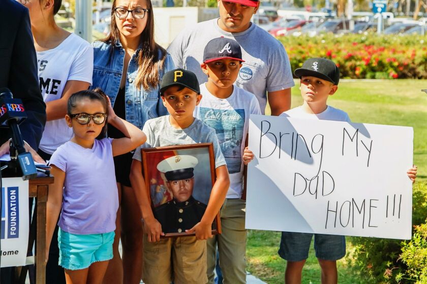 Family members of deported veteran Enrique Salas (Marine in framed photo) attend a press conference at the Veterans Museum in Balboa Park on Wednesday in San Diego, California.