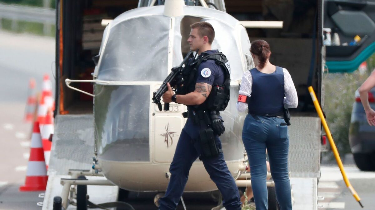 Armed police stand by as investigators transport an Alouette II helicopter said to have been abandoned by French prisoner Redoine Faid and suspected accomplices after his escape from prison.
