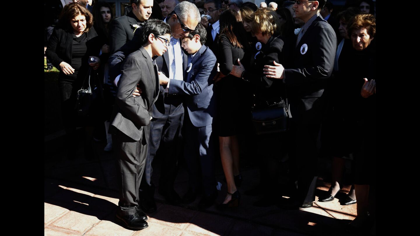 The husband and children of Bennetta Bet-Badal hug Monday following her funeral services at Sacred Heart Catholic Church in Rancho Cucamonga.