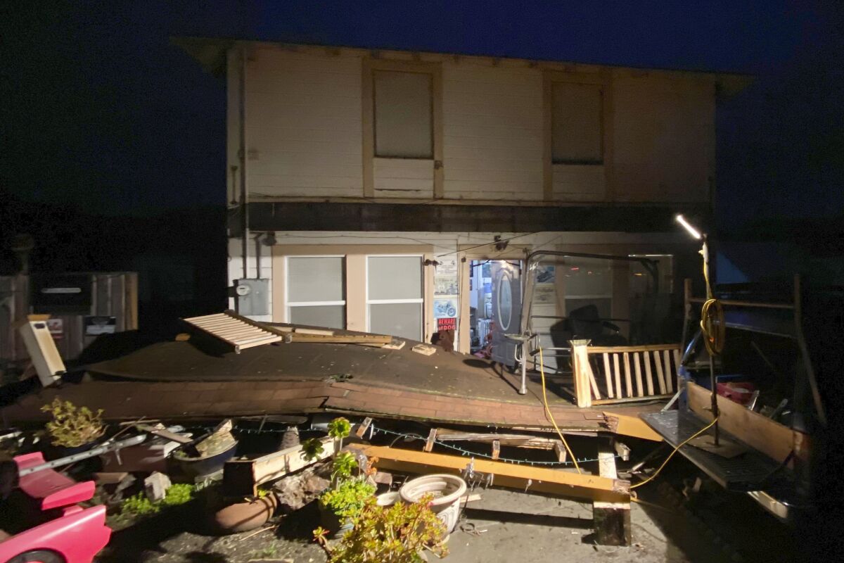 A collapsed deck outside a home.