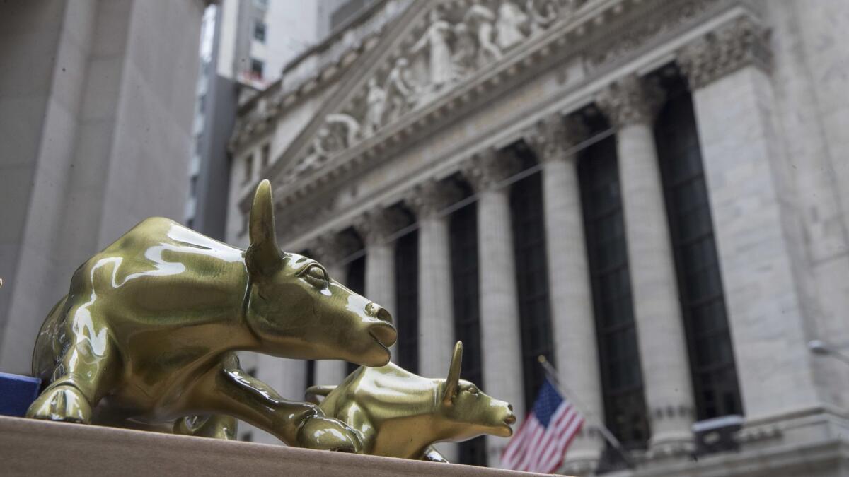 Small replicas of Arturo Di Modica's "Charging Bull" statue are for sale on a street vendor's table outside the New York Stock Exchange.