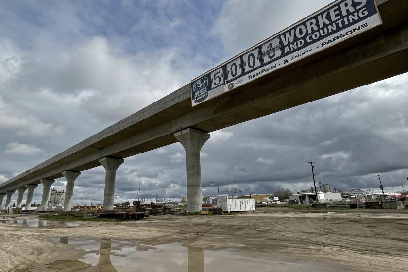 California rail authority banner claims 5,000 workers on the project on a viaduct in Fresno.
