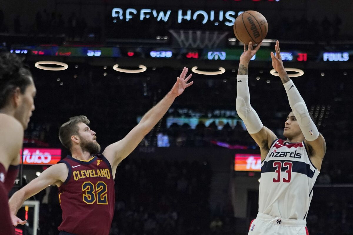Washington Wizards' Kyle Kuzma (33) shoots over Cleveland Cavaliers' Dean Wade (32) in the second half of an NBA basketball game, Wednesday, Nov. 10, 2021, in Cleveland. Washington won 97-94. (AP Photo/Tony Dejak)