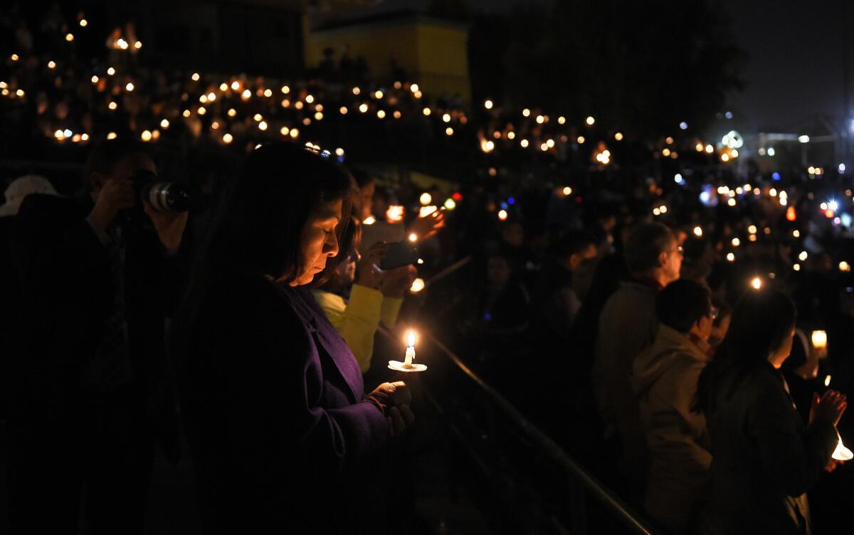 People hold a vigil at San Manuel Stadium in San Bernardino.
