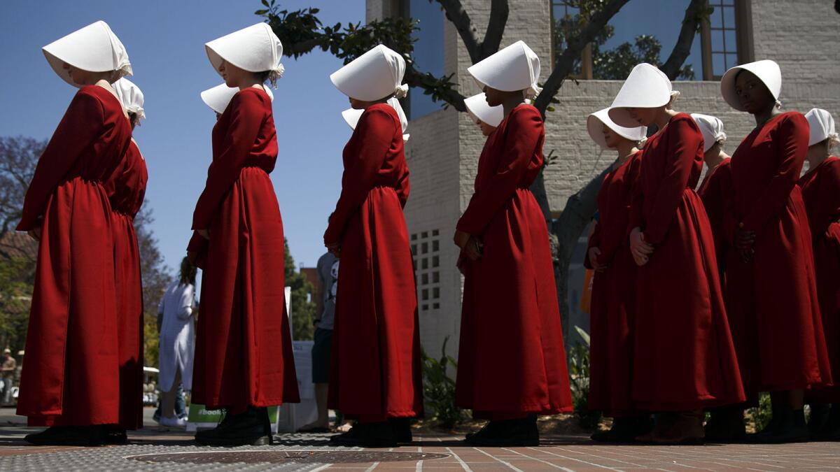 Actresses from the Hulu series "The Handmaid's Tale," based on the book by Margaret Atwood, stand in a row during the Los Angeles Times Festival of Books at the USC campus.