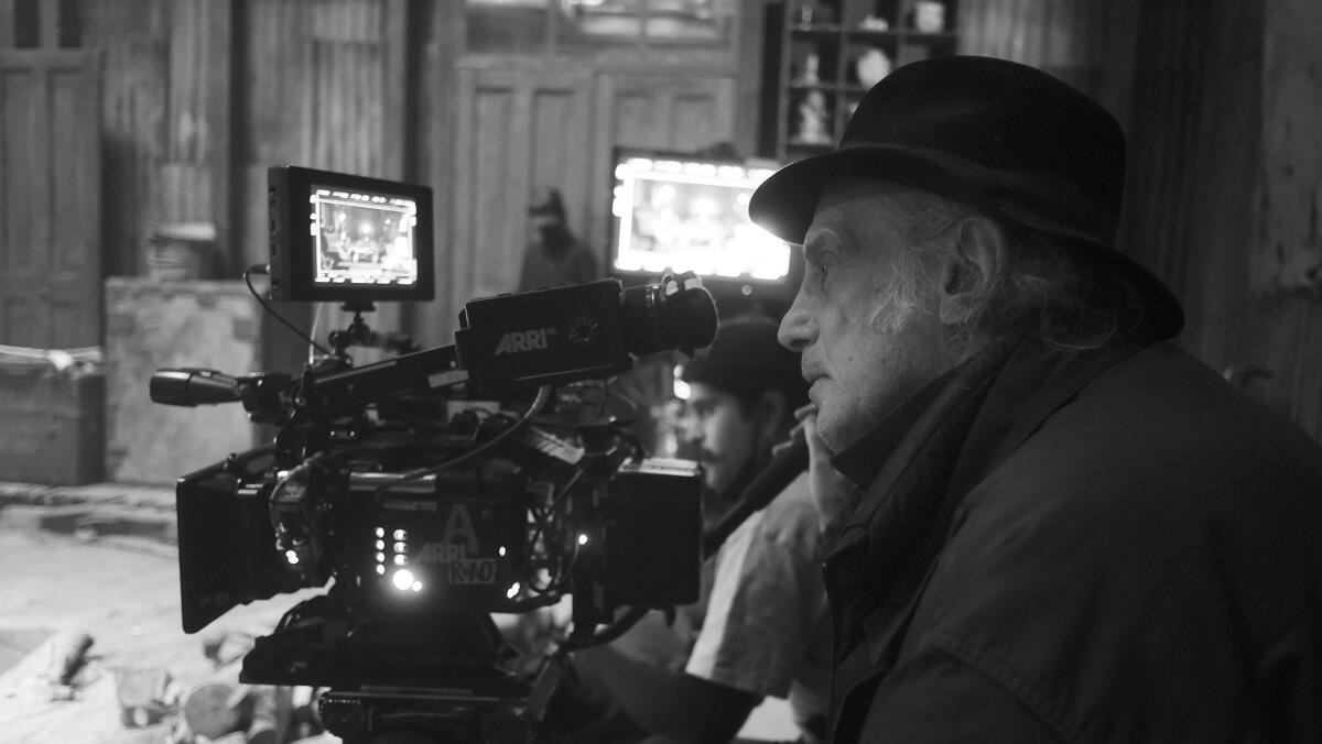 A man in a hat is shooting a movie.