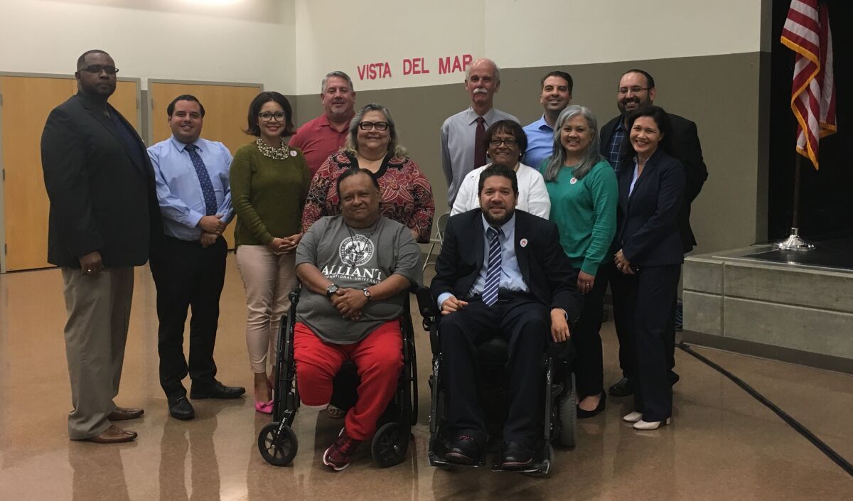 Members of San Ysidro's new bond oversight committee pose alongside governing board members and the district's superintendent during a meeting on April 11.
