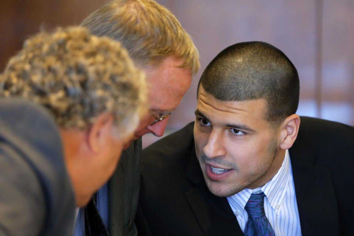 Aaron Hernandez (R), former player for the NFL's New England Patriots football team, talks to defense attorneys Michael Fee (L) and Charles Rankin during a court appearance at the Bristol County Superior Court in Fall River, Massachusetts October 9, 2013, in connection with the death of semi-pro football player Odin Lloyd in June. Hernandez, who was a rising star in the NFL before his arrest and release by the Patriots, has pleaded not guilty.