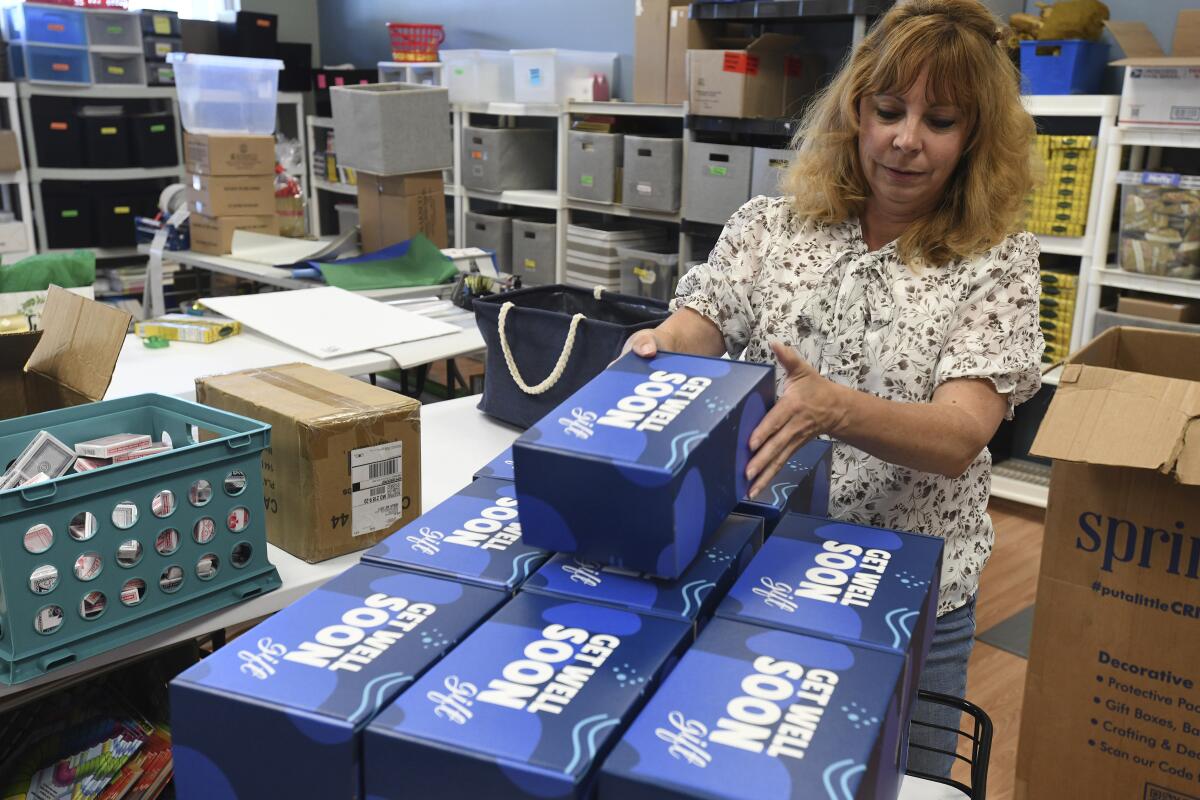 Kim Shanahan, who operates online store Gifts Fulfilled, stacks Get Well Soon boxes in her shop, Thursday, Sept. 8, 2022, in Berlin, Md. This is a fulfillment project for another company to create jobs at her company. (AP Photo/Todd Dudek)