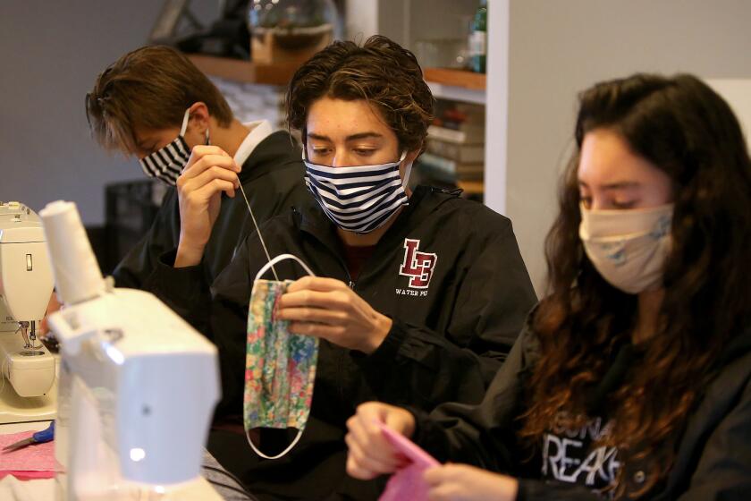 Student athletes Myha Pinto, Michael Pinto, and Jackson Golden, from right, sew and assemble homemade cotton masks for their "Sewing for SoCal" organization in Laguna Beach. They have already donated to doctors, hospitals, Laguna Food Pantry, and City of Laguna Beach.