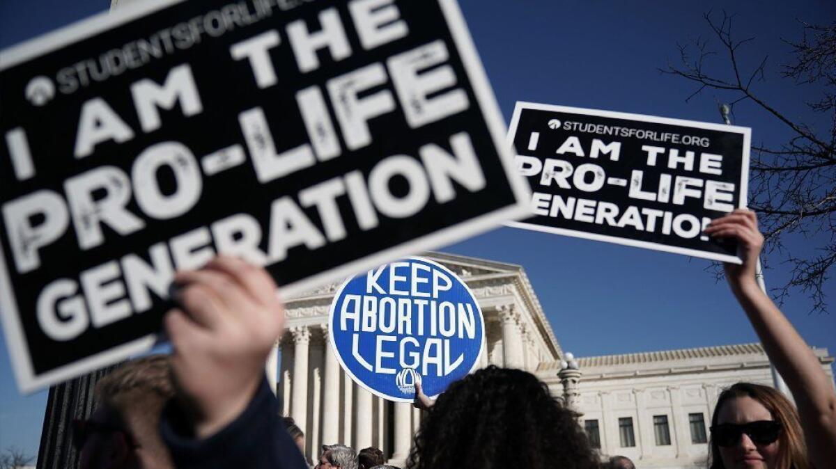 Anti-abortion activists try to block the sign of an abortion rights demonstrator during the March for Life in Washington on Jan. 19, 2018.
