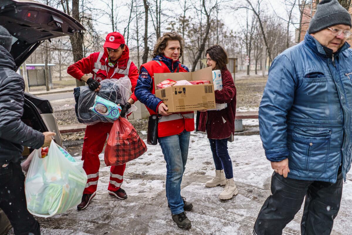 Red Cross workers deliver supplies to residents who have been cut off from humanitarian aid.