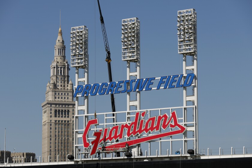 FILE - Workers finish installing the Cleveland Guardians sign above the scoreboard at Progressive Field, Thursday, March 17, 2022, in Cleveland. On Friday, April 15, the renamed Guardians will play for the first time at Progressive Field, officially launching a new era for a team known as the Indians since 1915 before a long-debated and fan-dividing name change finally happened last year. (AP Photo/Ron Schwane, File)