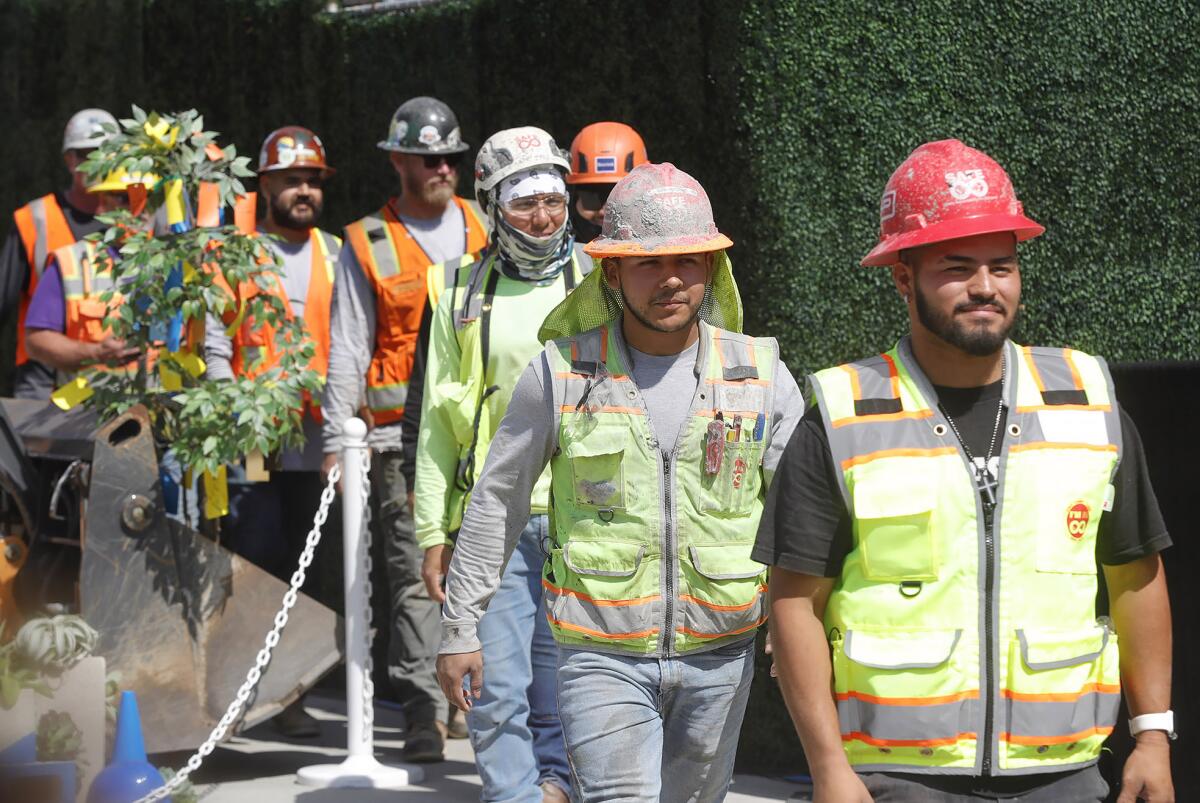 Iron workers are applauded as they walk by the audience during Wednesday's ceremony.