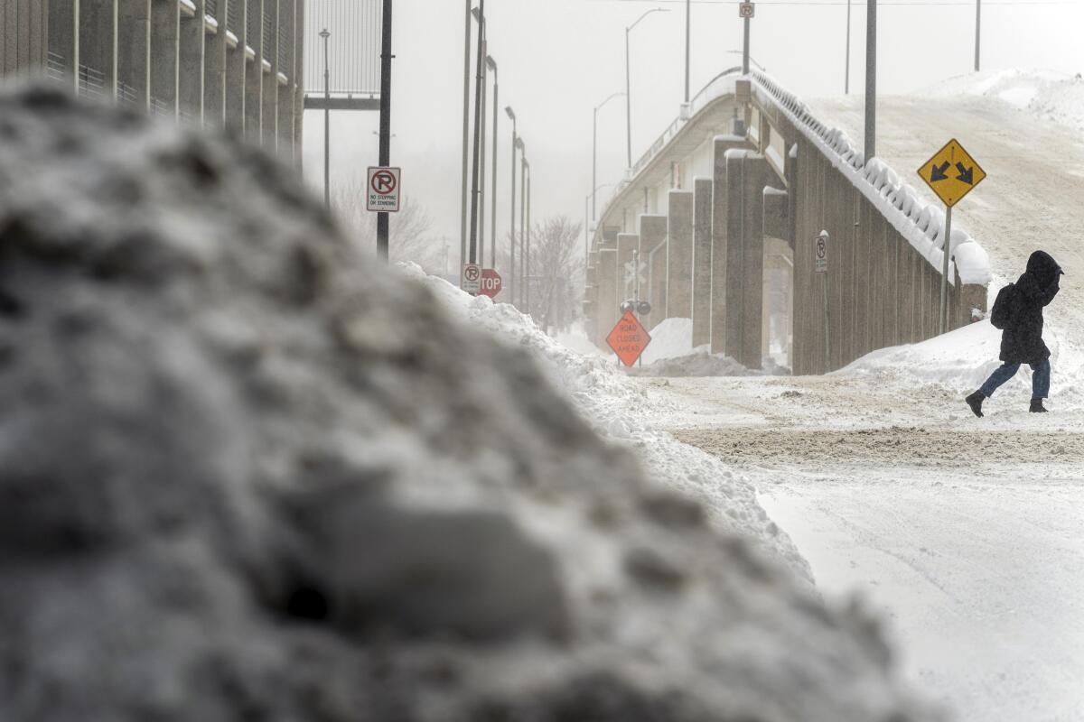 A woman walks through snow in downtown Des Moines, Iowa, Saturd