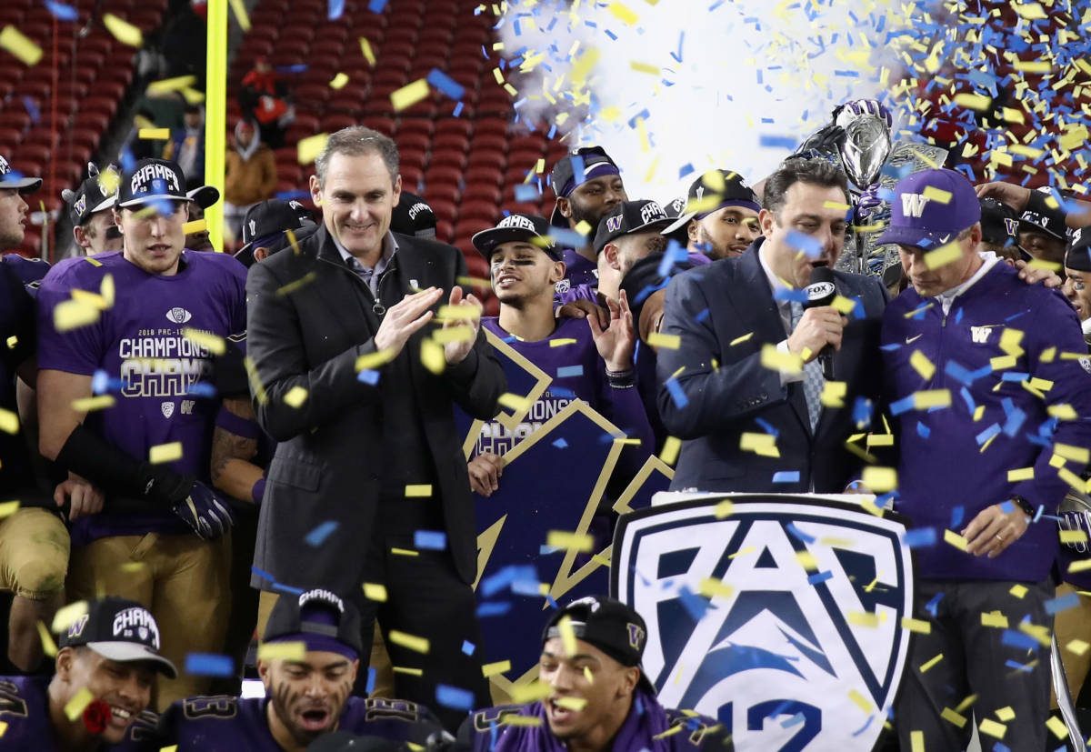 Pac 12 Commissioner Larry Scott stands on stage after the Washington Huskies were given the Pac-12 championship trophy
