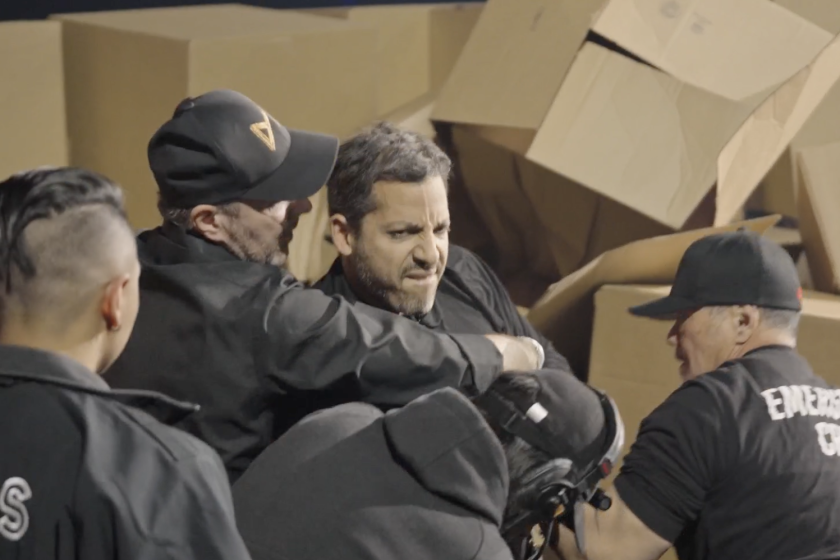 David Blaine surrounded by his medical team in front of pile of boxes moments after dislocating his shoulder in stunt