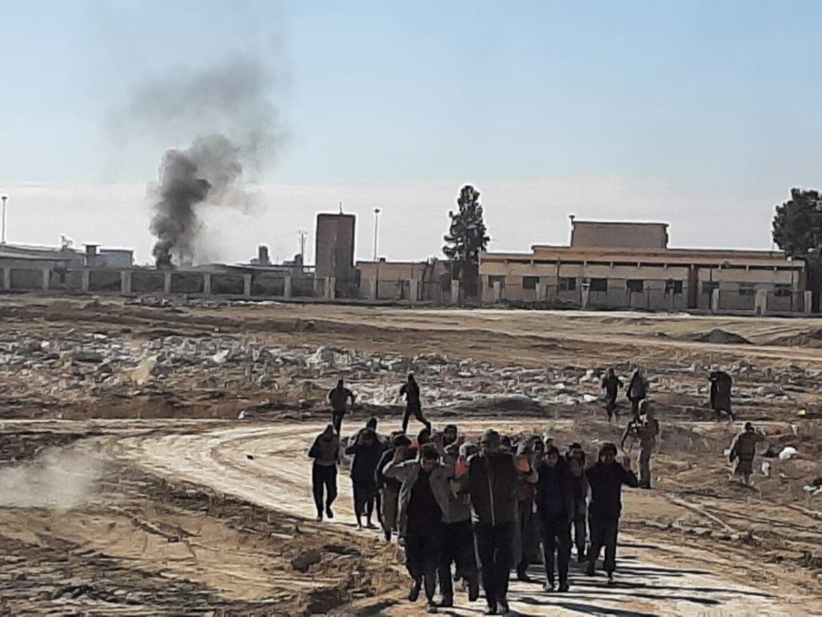 Islamic State fighters raise their hands up in surrender.