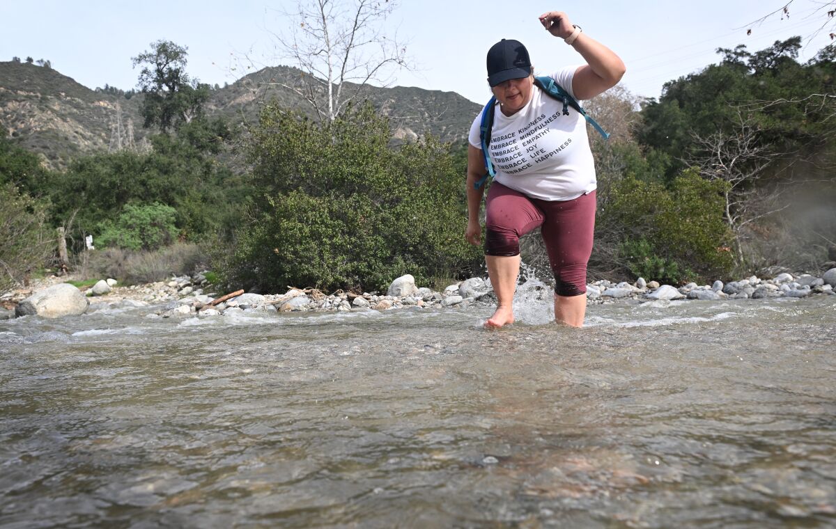 Linda Corella from San Bernardino navigates local hiking trails through a creek in Eaton Canyon. 