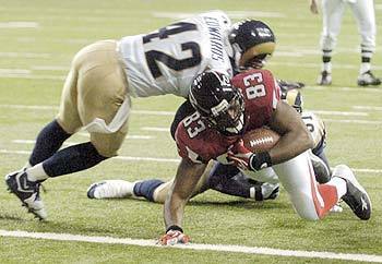 Atlanta Falcons tight end Alge Crumpler scores on an 18-yard touchdown reception under pressure from St. Louis Rams safety Antuan Edwards and safety Adam Archuleta.