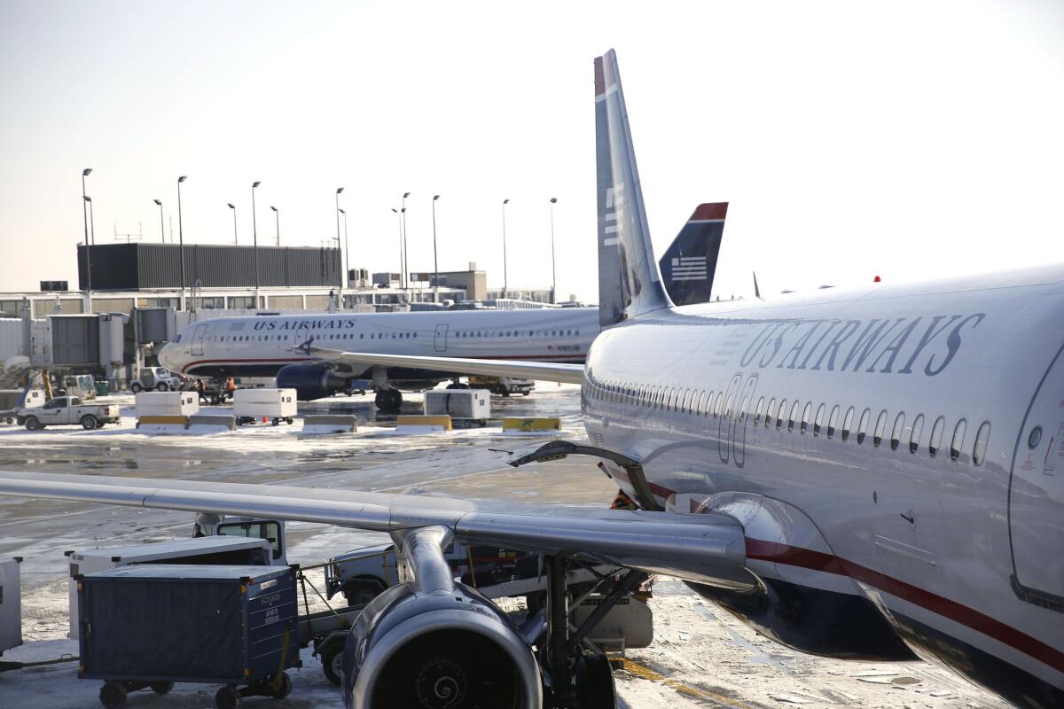 A US Airways plane is parked at its gate at O'Hare, seen here in a Tribune file photo. A passenger on a US Airways flight Oct. 8, 2014 from Philadelphia to the Dominican Republic was greeted by agents in hazmat suits after he allegedly made a joke about Ebola.