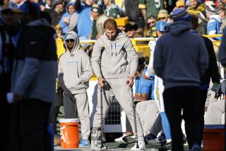 Joey Bosa hangs his head as he observes Chargers-Packers action from the sideline on crutches.