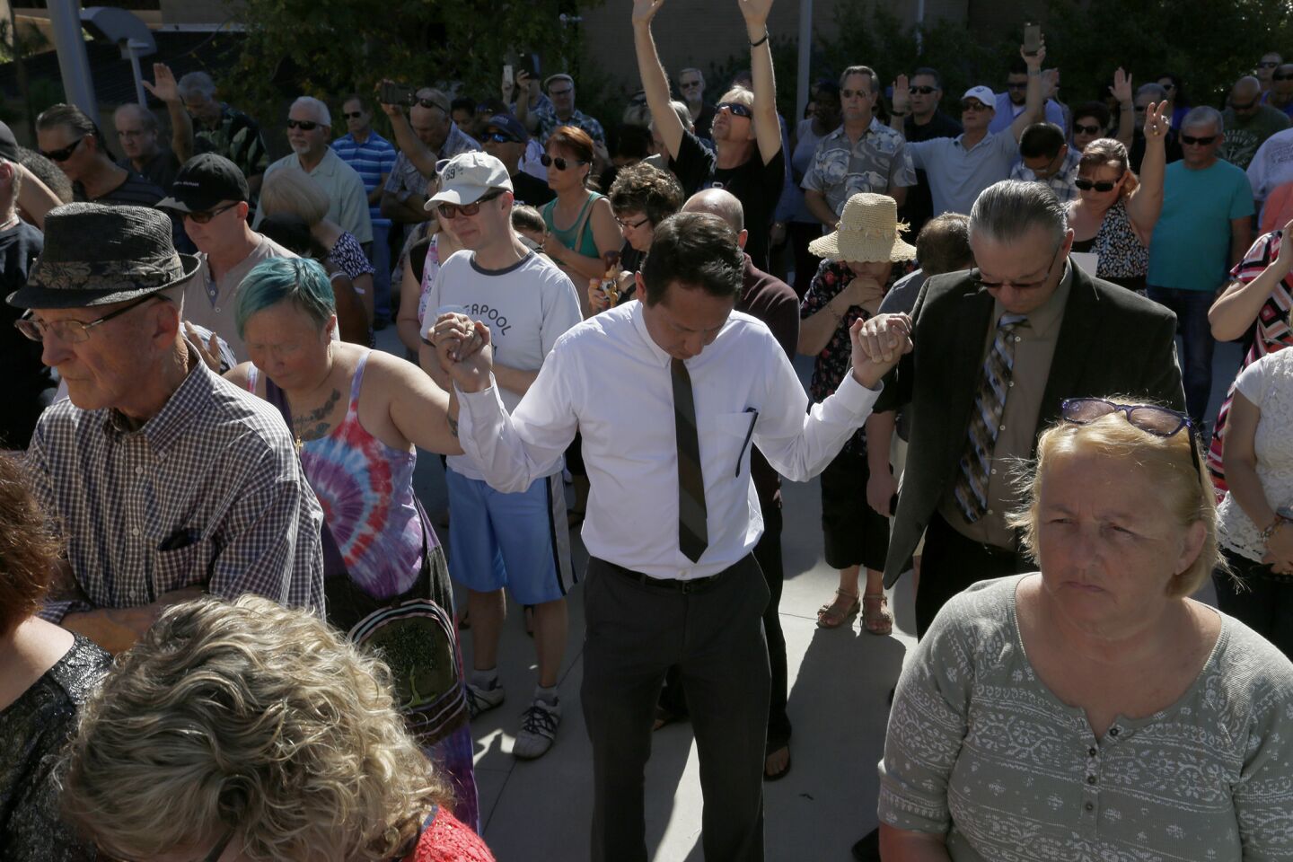 Members of the community pray outside the El Cajon Police Department.