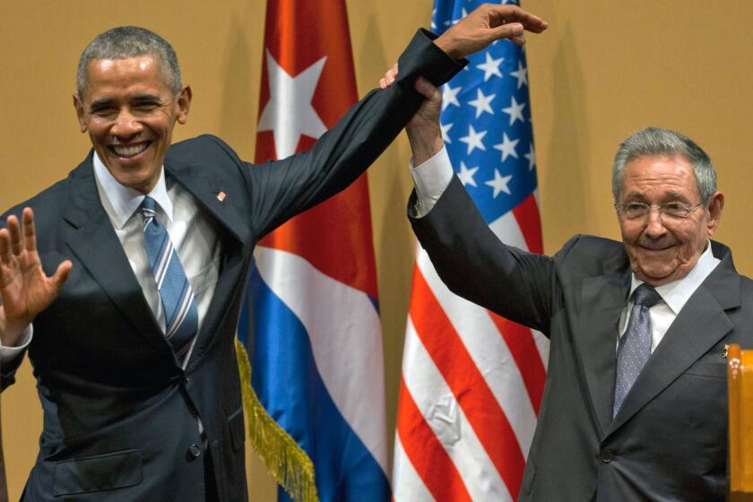 Cuban President Raul Castro lifts up the arm of President Barack Obama at the conclusion of their joint news conference at the Palace of the Revolution, in Havana, Cuba on March 21.