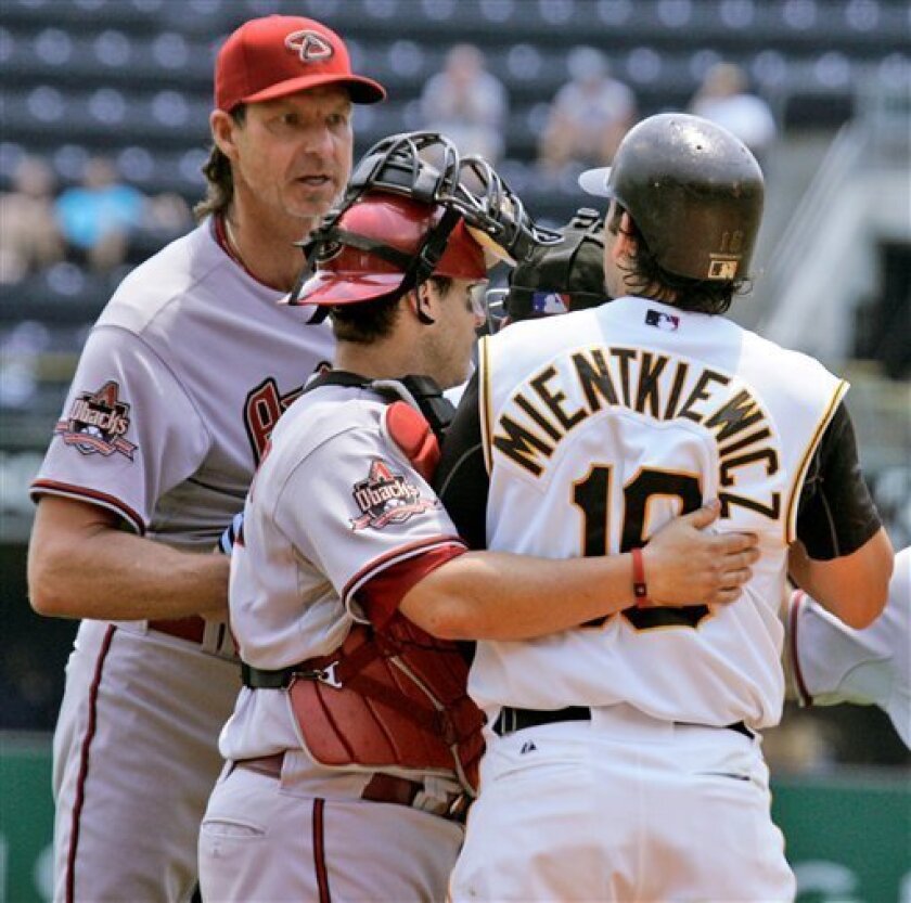 Pittsburgh Pirates' Doug Mientkiewicz, right, and Arizona Diamondbacks pitcher Randy Johnson, left, are restrained from getting to each other by umpire Chad Fairchild, rear right, and Diamondback catcher Miguel Montero, center, in the third inning of a baseball game at Pittsburgh, Monday, June 9, 2008. (AP Photo/Gene J. Puskar)
