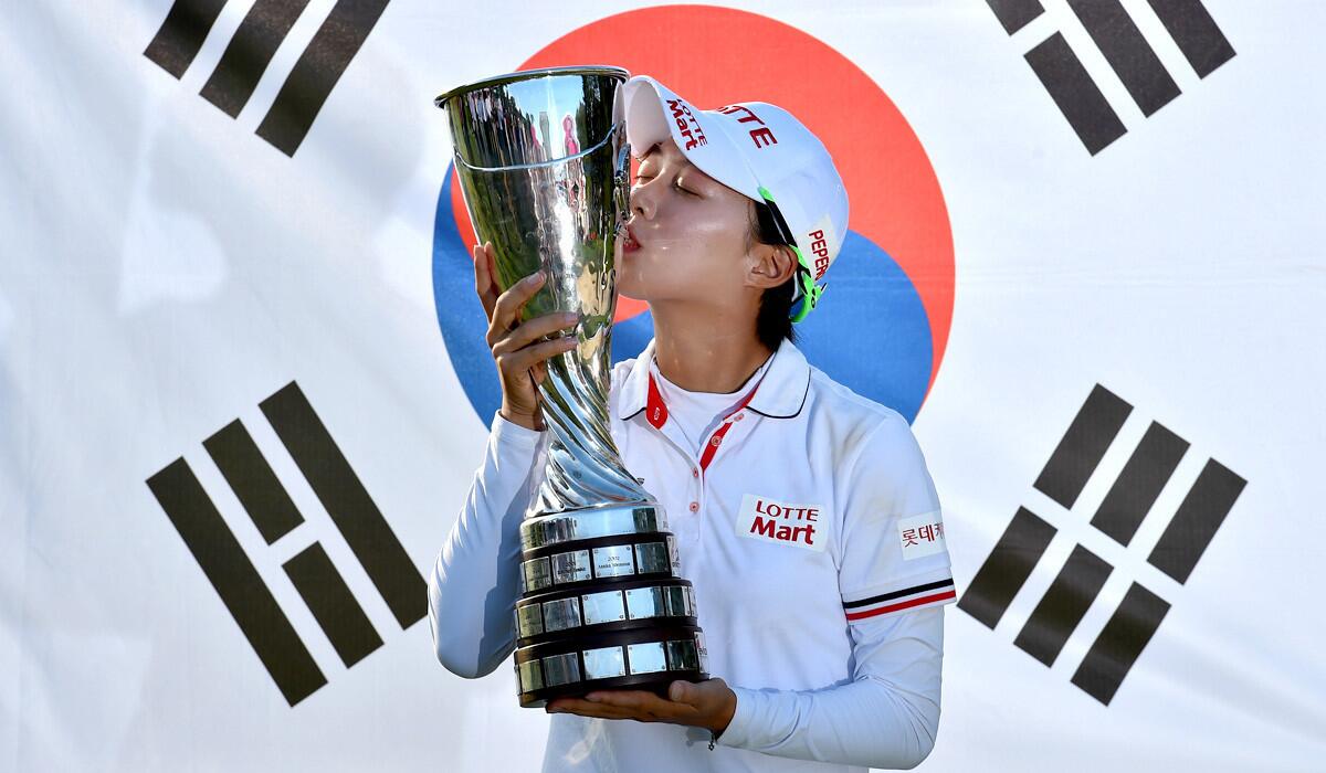 Hyo-Joo Kim celebrates with the trophy in front of a South Koran flag after winning the Evian Championship on Sunday.