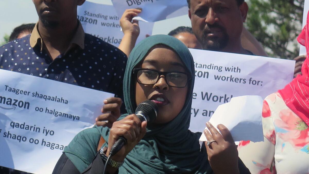 Nimo Omar speaks at a news conference demanding Amazon curb heavy workloads for East African workers at Amazon's warehouse in Eagan, Minn., as they fast and to let them take time off without penalty for Eid, the festival that ends Ramadan.