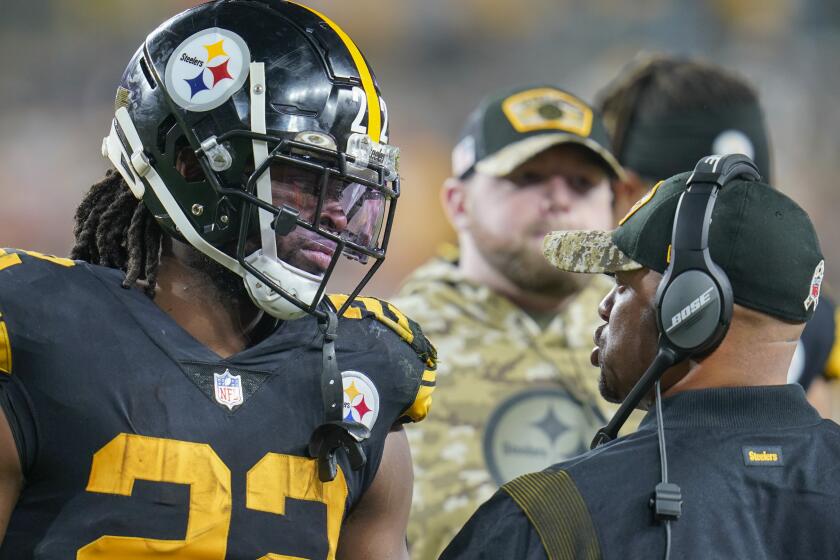 Pittsburgh Steelers running back Najee Harris (22), left, talks with head coach Mike Tomlin on the sideline during the first half of an NFL football game against the Chicago Bears, Monday, Nov. 8, 2021, in Pittsburgh. (AP Photo/Gene J. Puskar)