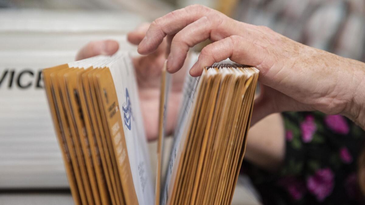 An employee of the Orange County Registrar of Voters sorts through mail-in ballots at their facility in Santa Ana on Nov. 7.